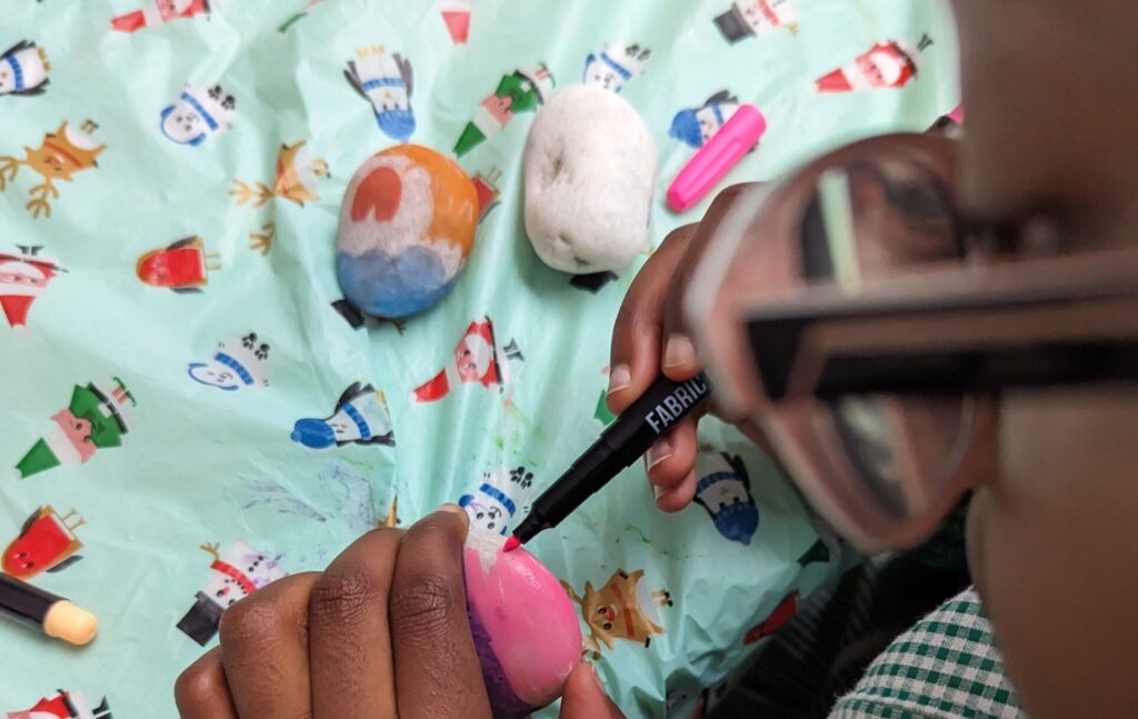 A child paining a stone.