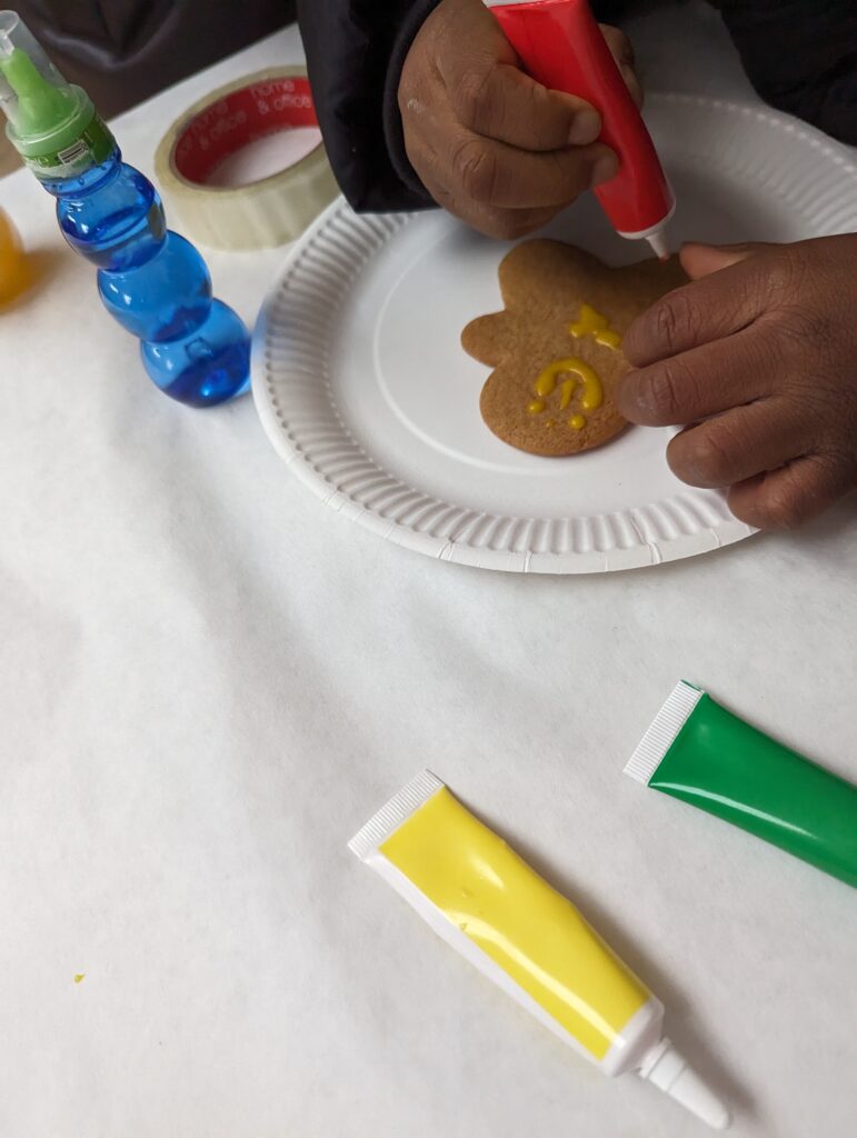 a child decorating a biscuit.